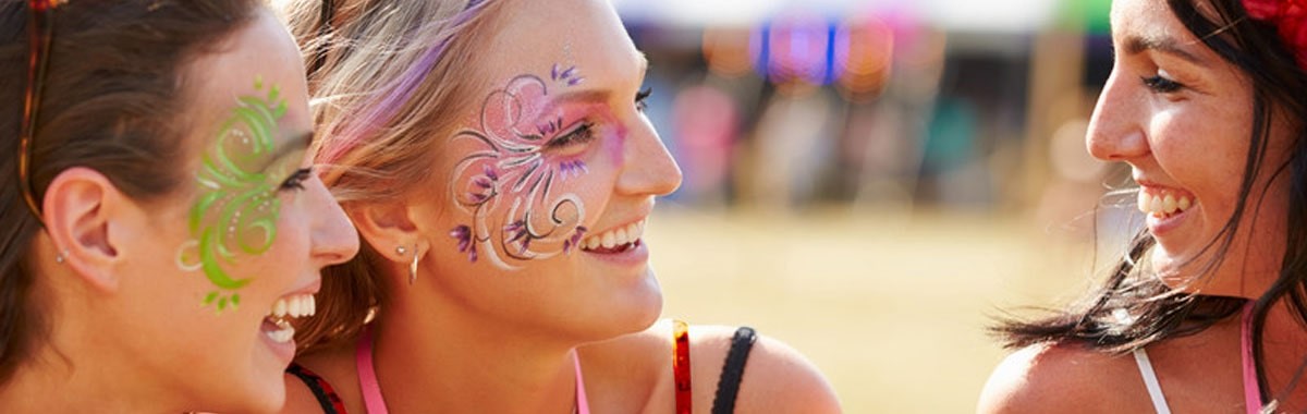 women with painted faces at a music festival