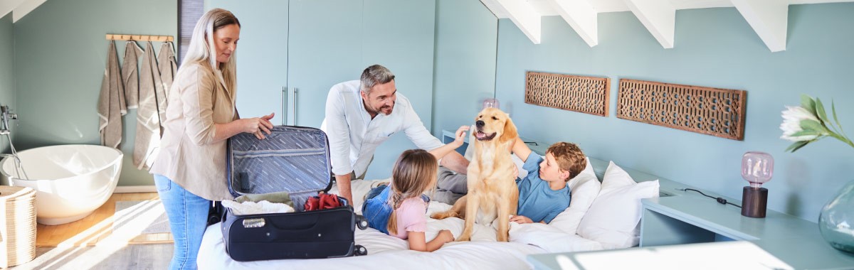 family with a dog in bed at a hotel